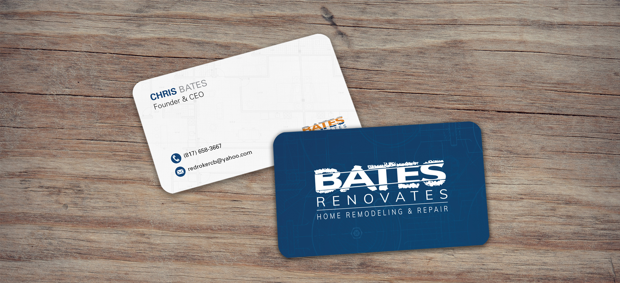 Executive business card set laying on a wooden background, demonstrating a print and digital collateral unification framework for Bates Renovates.